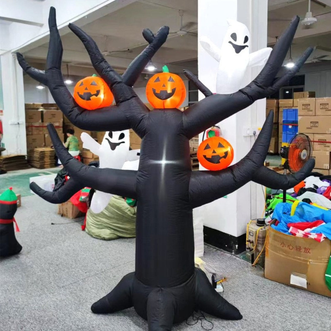 Inflatable black tree-like figure with pumpkin faces in a warehouse setting