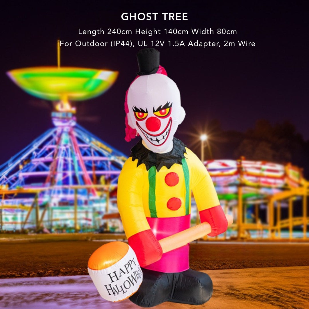 Inflatable clown with a 'Happy Halloween' bucket in front of a colorful Ferris wheel at night.