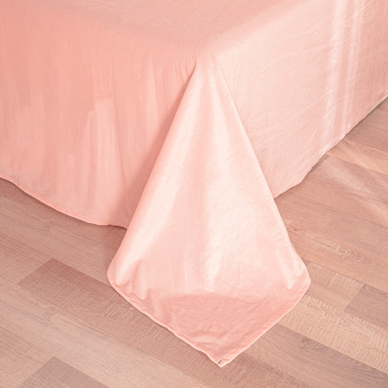 Pink quilt on a wooden floor