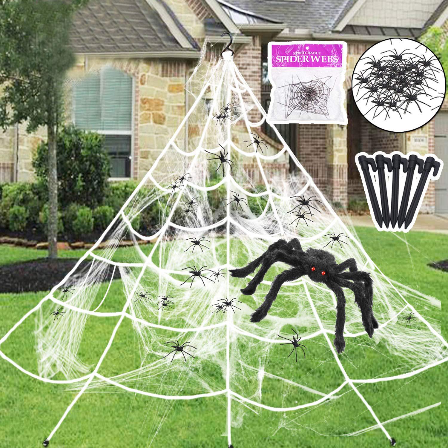 Halloween spider web with large spider and smaller spiders on a grassy lawn in front of a house.