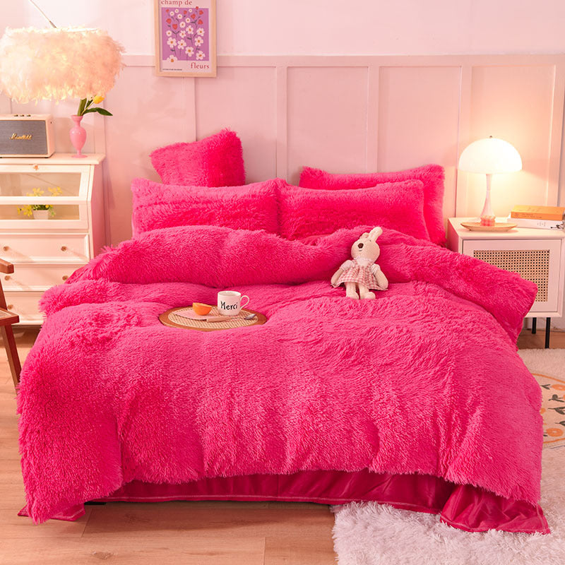 Fuchsia fluffy bedding set on a bed in a bedroom with a lamp and decor.