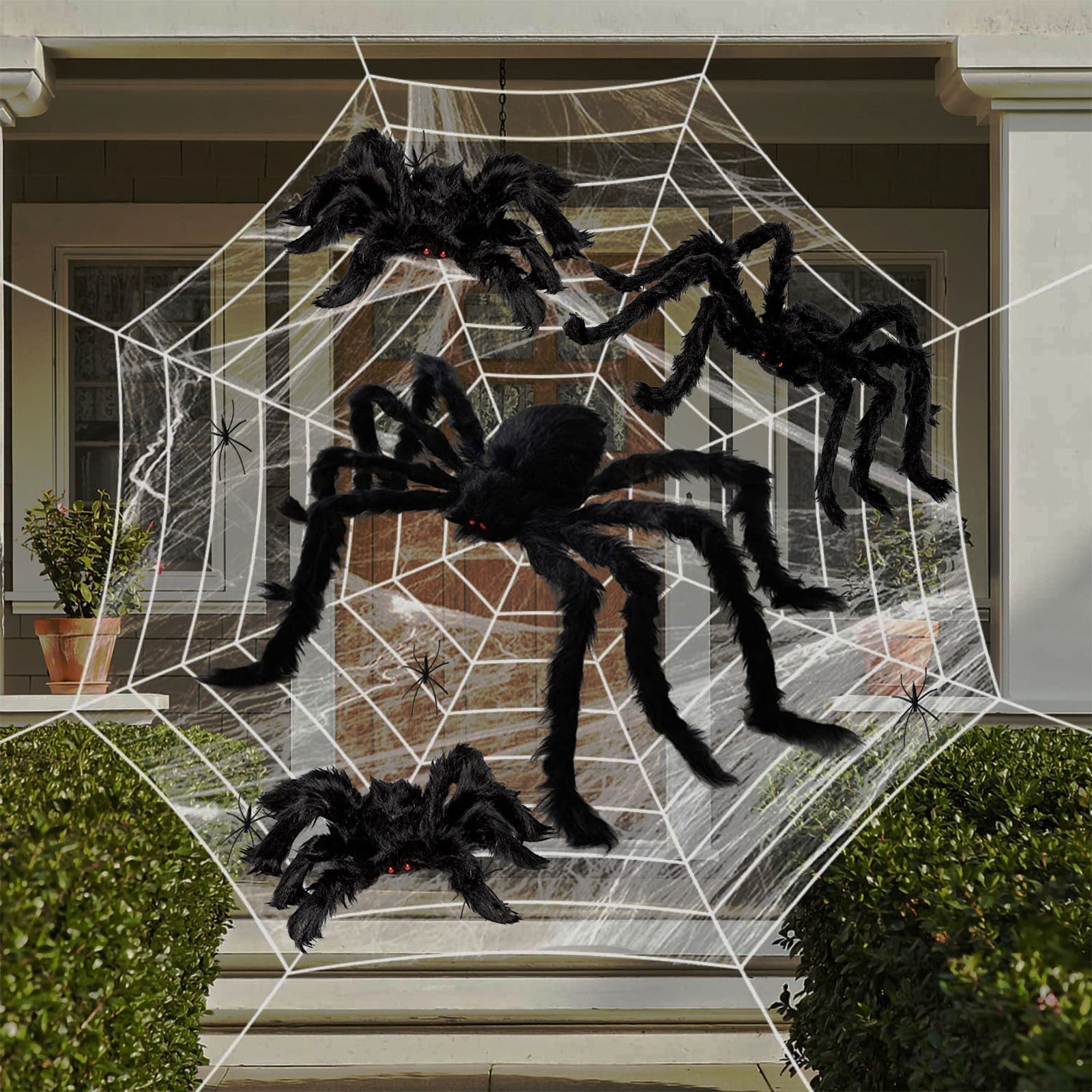 Halloween spider web decoration with large black spiders on a house exterior.