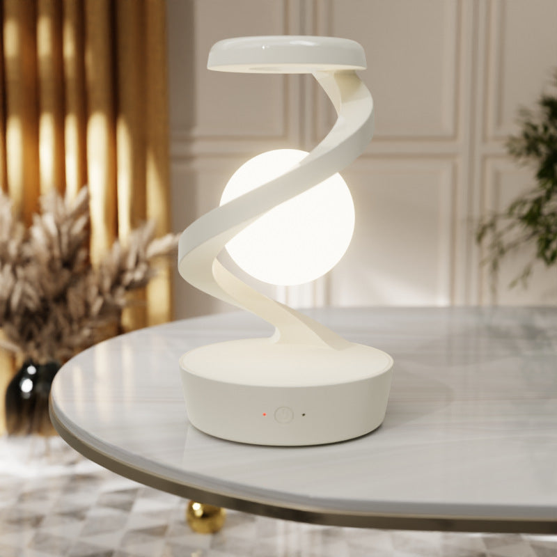 Modern spiral table lamp on a marble surface with decorative background