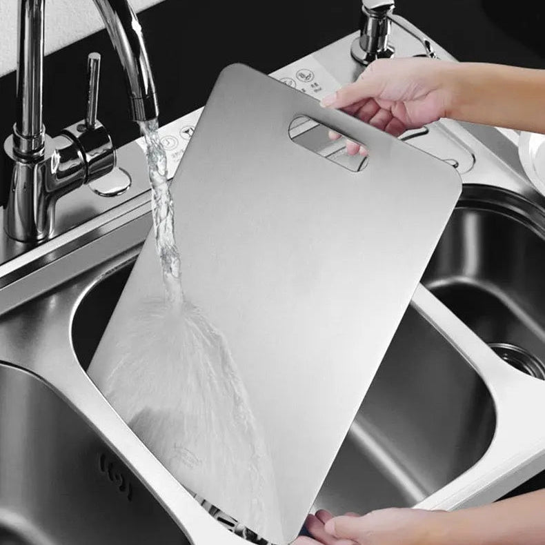Person washing a cutting board in a sink with text about thorough cleaning.